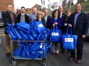 Partner Chris Didio and others posing with blue Red Cross bags
