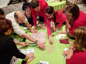 A group of Dannible & McKee, LLP employees playing a board game to raise money for charity