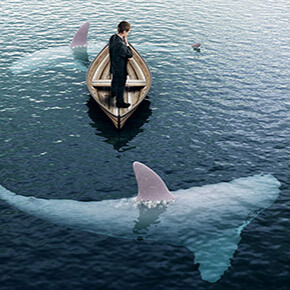 Sharks circling a man in small boat