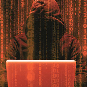 Hacker in hoody on computer