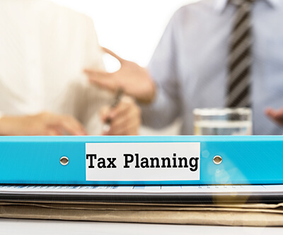 Tax Planning document folder with business team meeting with advisor tax plan services.