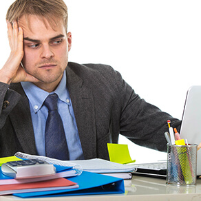 young desperate businessman overworked and upset looking worried and angry sitting at computer desk on white background office in business project stress problem