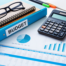 Budget planning reports, Blue budget binder, glasses, calculator and business chart