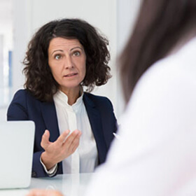 Business woman with black suit and white shirt in concerning discussion with girl