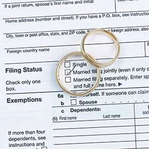 Wedding rings with United States tax form 1040 over filing status with married checked in middle of one ring