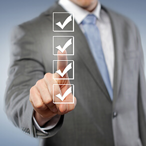 Square image of man in business suit pointing at checkmarks in a list