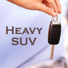 Womans hand holding car key with "heavy suv" next to it