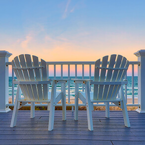 Adirondack Chairs on the deck of a vacation home looking at beach