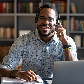 Happy young african american man wearing headset, looking at camera, remote selling.