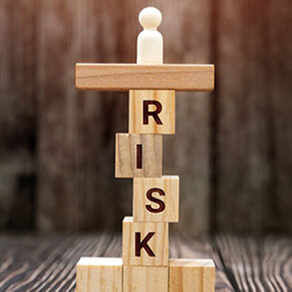 Blocks that spell the word "risk" stacked on top of each other