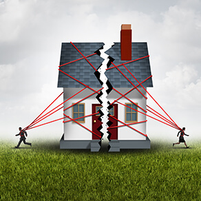 A house being pulled apart by two people and multiple red strings
