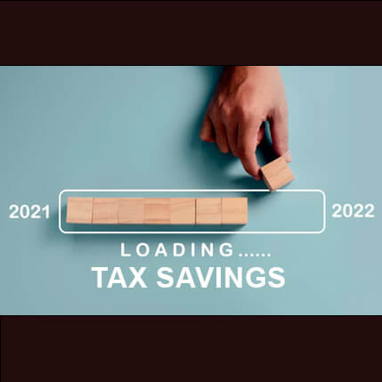 Hand lining up blocks in a row with the years 2021 and 2022 on either side with the words loading tax savings