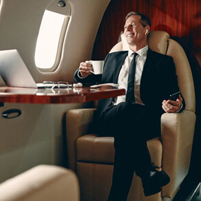 Man in suit sitting in a private plane looking out of a window