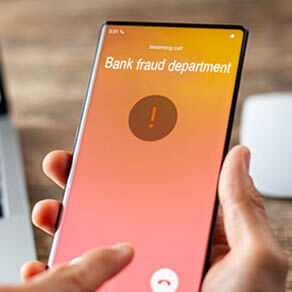 Hand holding cell phone with image of "Bank Fraud Department" calling