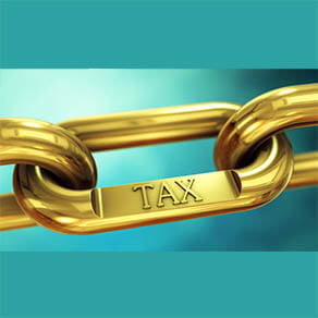 Close up of a gold chain link with the word "tax" on a link