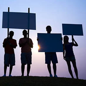 Silhouettes of people holding signs