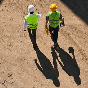 Two construction workers walking on a job site