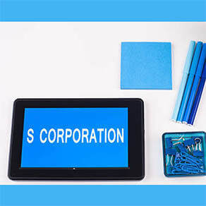Business Phrase on Tablet PC - Blues, cup of coffee, Pens, paper clips Calculator with a blue note pad on White - White Word(s) on blue - S Corporation