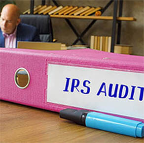 Financial concept about IRS AUDIT Internal Revenue Service with inscription on the Box File. Businessman working with documents sending email, mobile phone