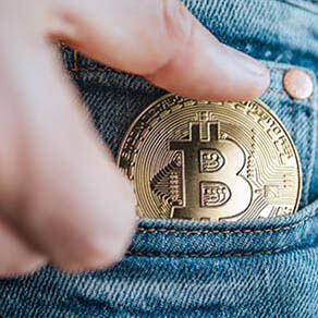 Close up footage of man's fingers putting the Bitcoin coin in the blue jeans small pocket. Savings, digital currency, cryptocurrency, investing, and smart outgoings managing concept.