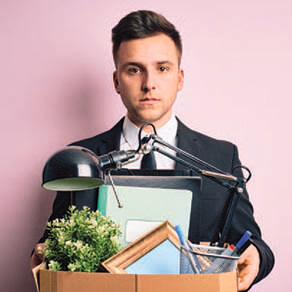 Man in suit holding box containing items from an office desk