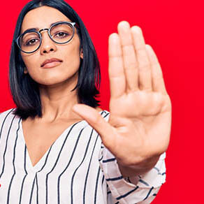 Young beautiful latin woman holding touchpad with open hand doing stop sign with serious and confident expression, defense gesture