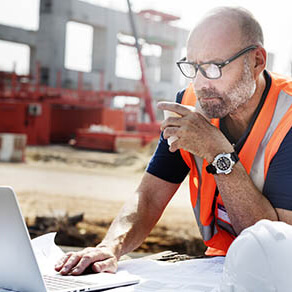 Construction man working intently on laptop computer