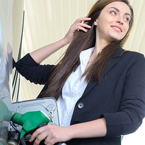 Business woman at gas station filling car