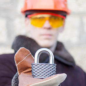 Industrial engineer offers padlock in a hand. Security Industry concept. Secure Work Engineering Manufacturing.
