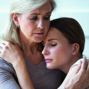 Woman being comforted by another woman with her head on her shoulder