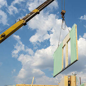 Crane lifting wall of a house