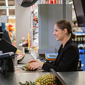 Woman ringing out a customer's groceries at a store